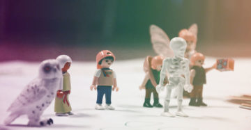 Nahaufnahme: Playmobil-Figuren stehen arrangiert auf Papier